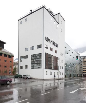 Michl Schmidt + Peter Wendl: Verteidigung des Normalzustands – Haussegen an der Fensterfront des Adambräu:
"Herr, behuete uns dies Haus fuer Feuersnoth,
fuer Pest und den boesen schnellen Todt."